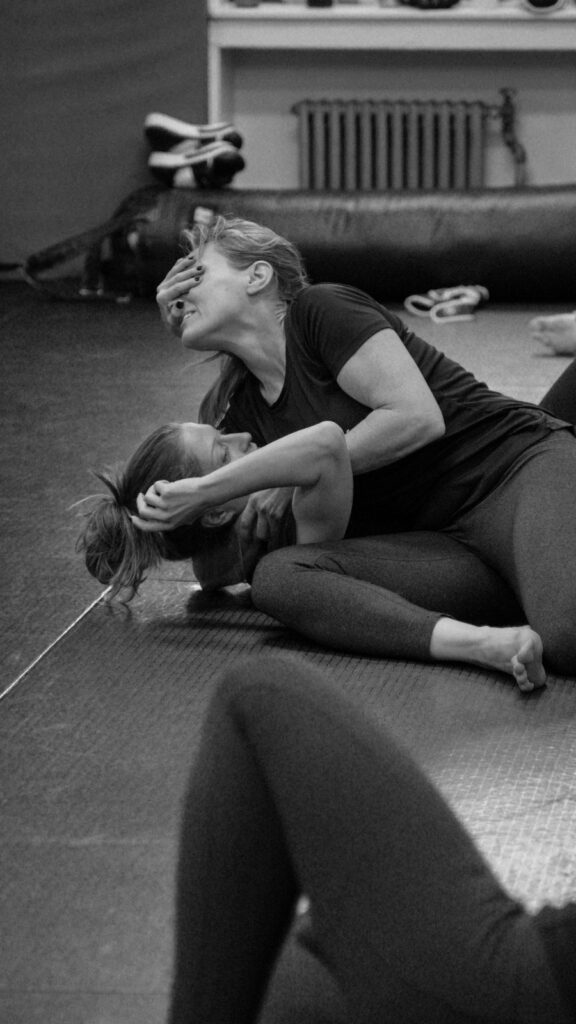 Two women practicing a ground headlock escape during women’s self-defense training in New York City.